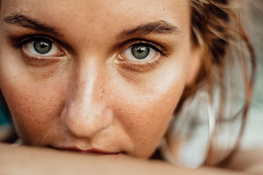 Close-up macro portrait of a woman's face highlighting natural skin texture, visible pores, and subtle shine, ideal for demonstrating targeted skincare routines for oily skin types.