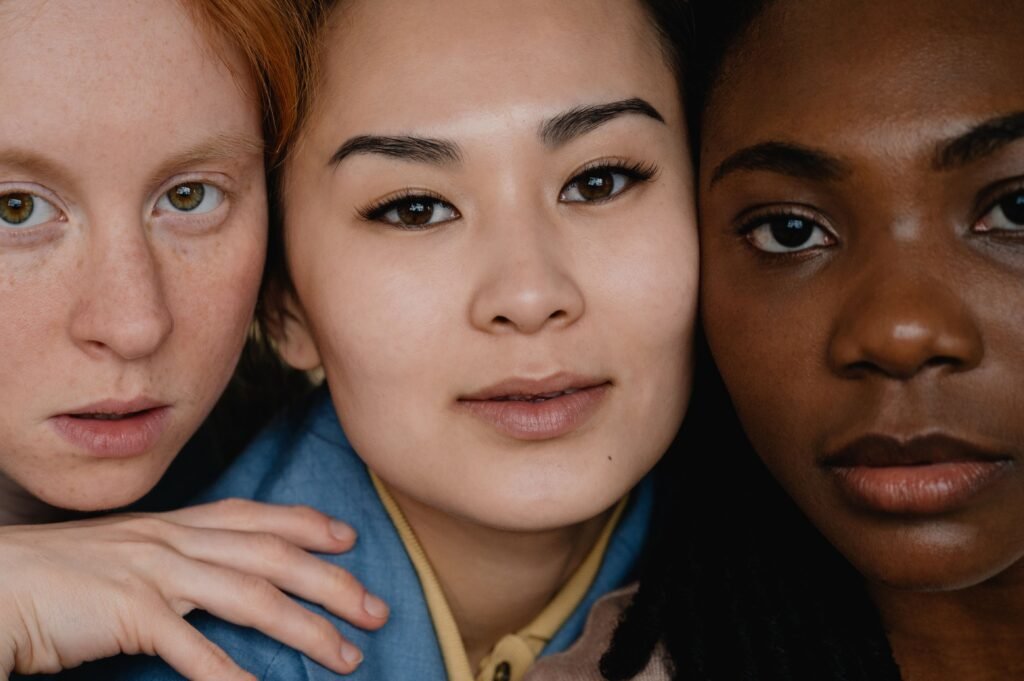 Close-up of three women with diverse skin tones, showcasing how to know your skin type by identifying unique textures.